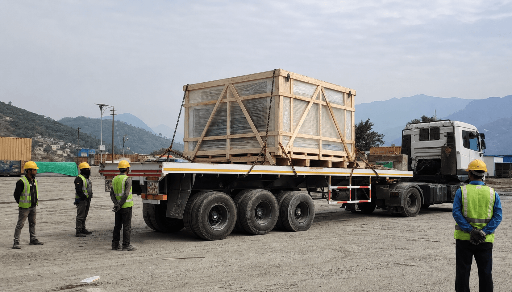 Side view of a high bed flat trailer carrying secured industrial machinery in Nepal